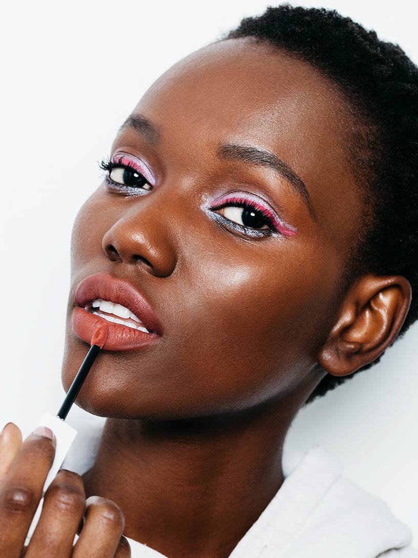 Woman with Festival Fare look, applying Matte Ink lipstick